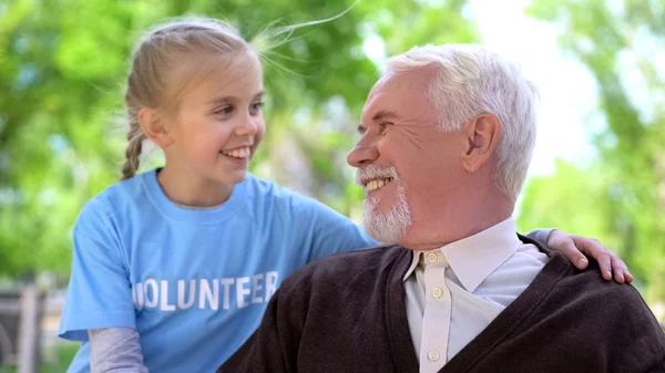 Ευτυχισμένο Παιδί Εθελοντής Αγκαλιάζοντας Αρσενικό Συνταξιούχο Χαμογελώντας Ένας Τον Άλλο — Φωτογραφία Αρχείου