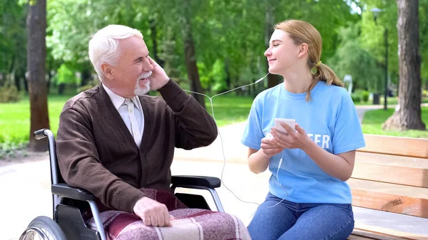 Счастливая Молодая Женщина Слушает Музыку Стариком Инвалидом Поддерживает Пациента — стоковое фото