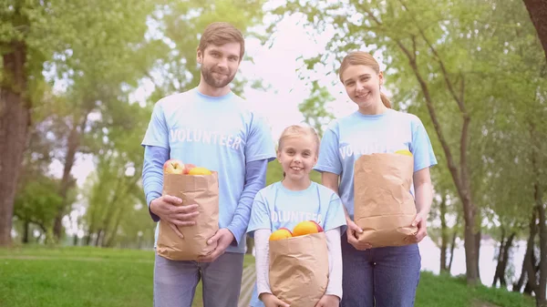 Чоловіки Жінки Діти Добровольці Тримають Паперові Мішки Фруктами Усміхнену Камеру — стокове фото