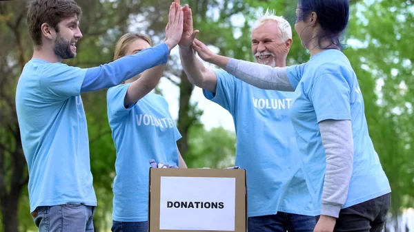 Ativistas Felizes Colocando Caixa Doação Roupas Dando Mais Cinco Voluntariado — Fotografia de Stock