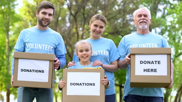 Volontari Sorridenti Possesso Scatole Donazione Alla Ricerca Fotocamera Progetto Beneficenza — Foto Stock