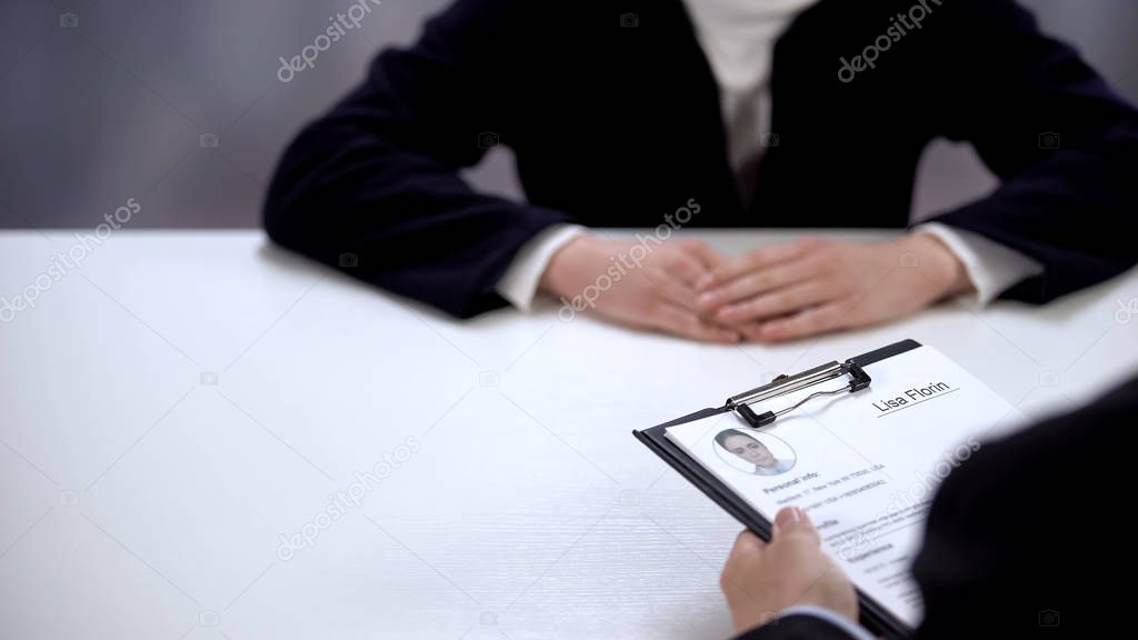 HR manager holding curriculum vitae of female applicant, job interview close up