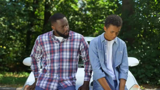 Afro-american dad demanding car key teenage son car background, parent control — ストック動画