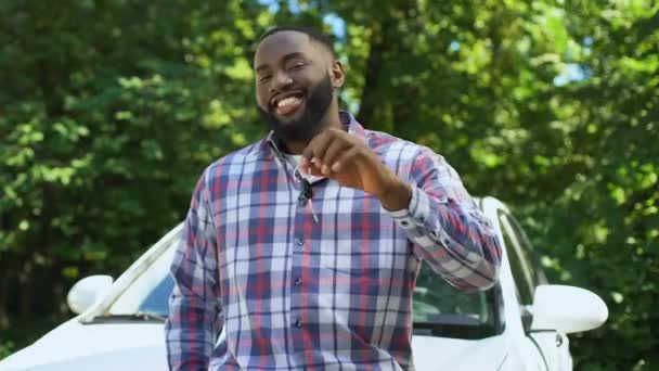 Le afro-amerikan man visar bilnycklarna lutar ny bil, hyra service — Stockvideo