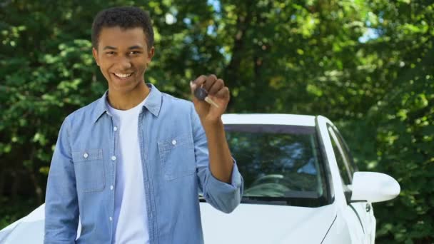 Joven hombre negro sosteniendo la llave del automóvil, compra de transporte, licencia de conducir — Vídeos de Stock