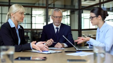 Ofis müdürü nde tartışan sinirli iş kadınları iş arkadaşlarına bakıyor