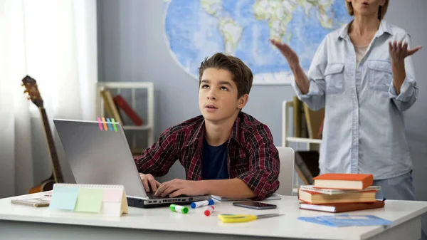 Schoolboy Sidder Laptop Følelse Træt Skælde Mor Stående Bag Alder - Stock-foto