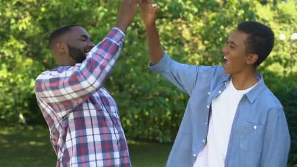 Verrukte zwarte mannen geven high five, gelukkige broers genieten van tijd samen — Stockvideo