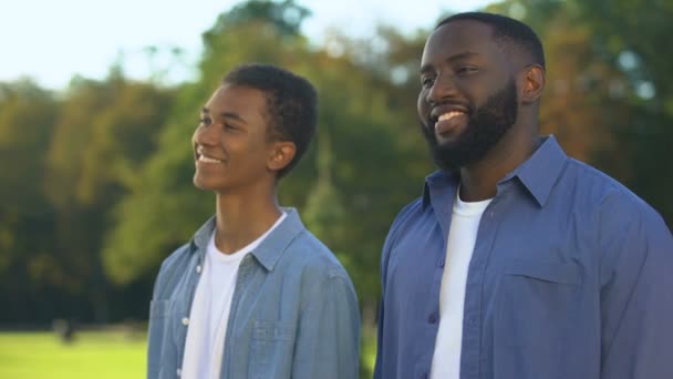 Joyeux parent et enfant mâle debout à l'extérieur se souriant, la proximité — Video