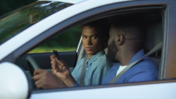 Strenger Papa checkt Sohn Smartphone sitzend Auto, Generationenkonflikt, Elternschaft — Stockvideo