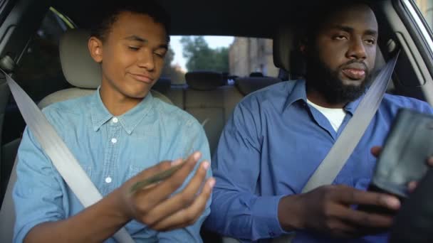 Hijo pidiendo dinero de bolsillo de padre insatisfecho sentado en el coche, brecha de generación — Vídeos de Stock