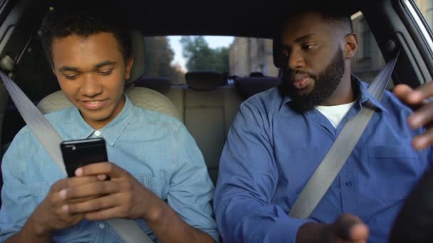 Афро-американец читает сын смартфон сообщение, отношения конфликт, поведение — стоковое видео