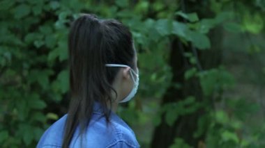 Güvenlik maskesi takan bir kadın ormanda yürüyor, hava kirliliği, çağdaş sorunlar