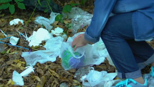 Dziewczyna ratuje planetę przed plastikową torbą w gruzach, pomagając zanieczyszczonej Ziemi — Wideo stockowe