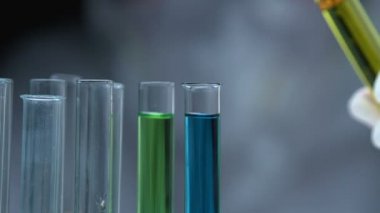 Araştırma görevlisi test tüpüne yanıcı sıvı dökerek petrol özelliklerini analiz ediyor.