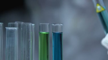 Bilim adamı kimyasal bileşimi analiz etmek için tüpün içine zehirli sıvı ekliyor.