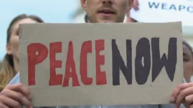 Bayraklı protestocular teröre karşı şimdi barış, savaş karşıtı hareket diye bağırıyorlar.
