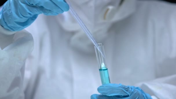 Researcher in protective suit and gloves taking dangerous liquid sample, poisons — Stock Video