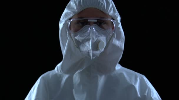 Donna scienziata in maschera protettiva, occhiali e accappatoio facendo pericolo gesto spaventoso — Video Stock