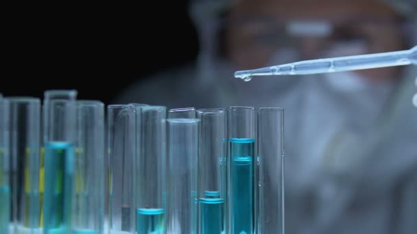 Investigador que gotea líquido químico en el tubo, analizando las propiedades de la sustancia — Vídeo de stock
