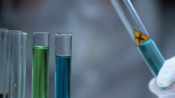 Mão em luvas de proteção derramando substância irritante no tubo de ensaio, laboratório químico — Vídeo de Stock