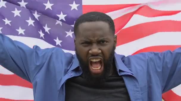 Furious afro-american man raising US flag, anti-racist rally, migrant crisis — Stock Video