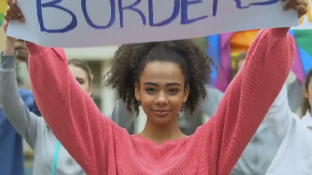 Biracial κορίτσι κρατώντας αγάπη χωρίς σύνορα αφίσα μαζί με ακτιβιστές Lgbt — Αρχείο Βίντεο