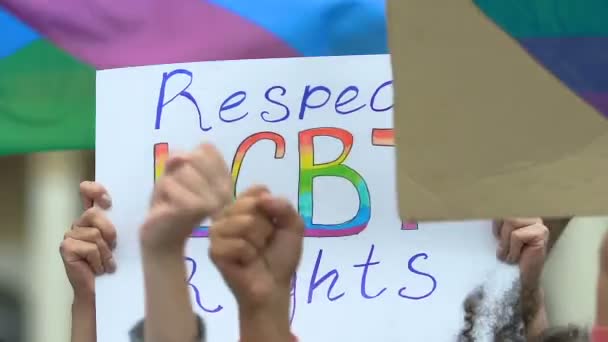 Activistas coreando con las manos levantadas ondeando pancartas por los derechos LGBT, marcha del orgullo — Vídeo de stock