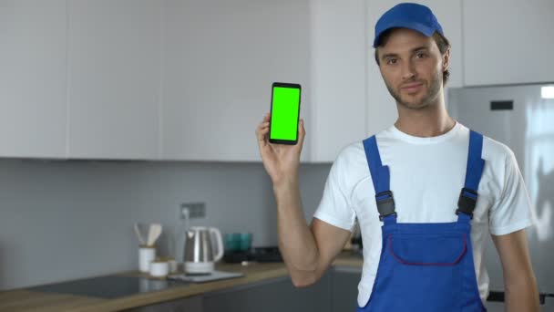 Man in uniform showing phone with green screen, booking of house repair service — Stock Footage Man in uniform showing phone with green screen, booking of house repair service Royalty Free Stock Footage