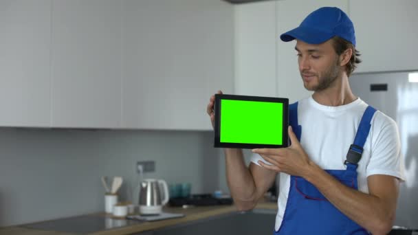 Handyman visar tablett med grön skärm, annons för underhållsarbete, service — Stockvideo