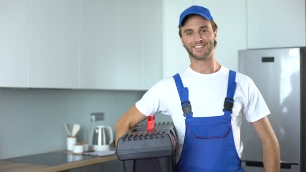 Handyman sosteniendo herramientas de pie en la cocina, servicios profesionales de fontanería — Vídeo de stock