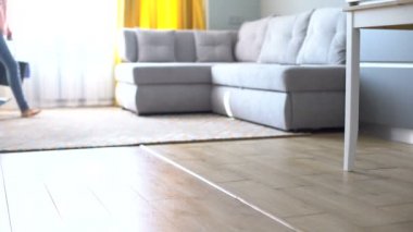 Kovayla ve paspasla yürüyen çıplak ayaklı kız, ev temizleme servisi reklamı.