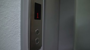 Kadın parmak asansör düğmesine basıyor, 1 'den en üst kata çıkıyor, yakın plan.