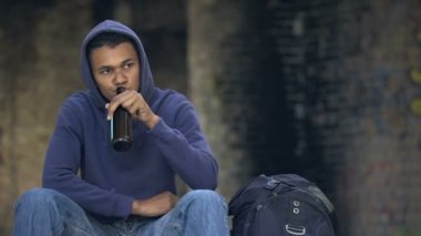 Sorunlu genç dışarıda şişeden bira içiyor, ergenlik yaşı bağımlılığı