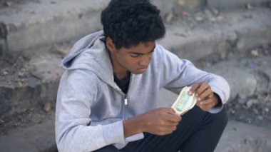 Mutsuz siyah erkek elinde dolar banknotları, mali kriz, sorun