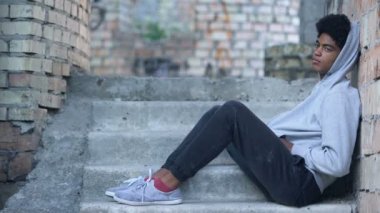 Yalnız genç erkek merdivenlerde oturuyor, yanlış anlaşılma depresyon, sorun