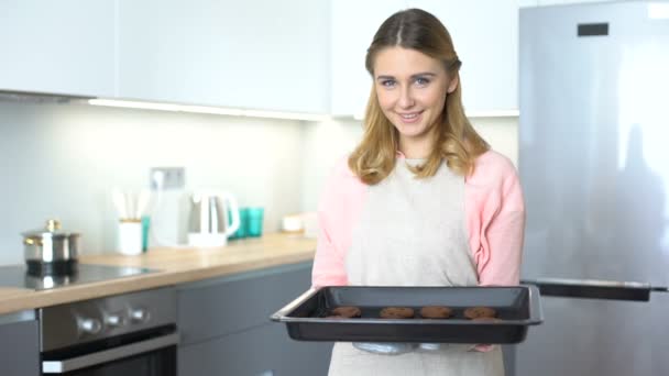 Cheerful housewife in apron holds baked cookies, delicious pastry advertisement — Stock Video