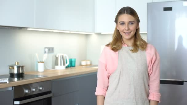 Jolie femme au foyer élevant ustensiles de cuisine, cours de cuisine publicité, modèle de menu — Video