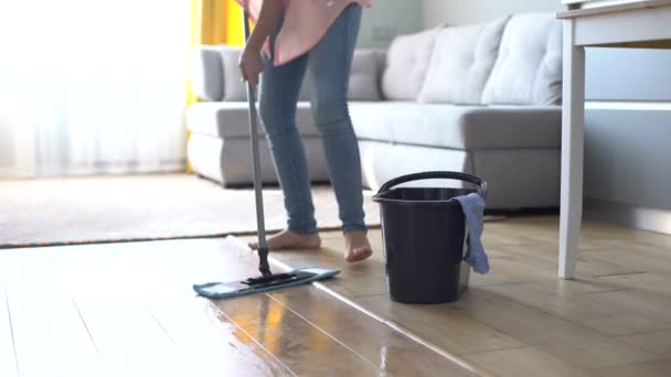 Gadis tanpa alas kaki mengepel lantai, menjaga kebersihan dan kebersihan di rumah, tips — Stok Video