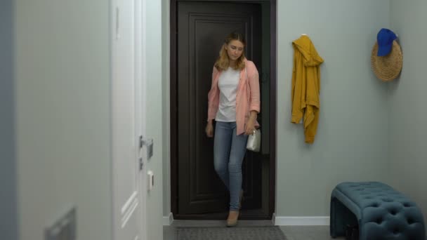 Frau betritt Wohnung, zieht Schuhe aus, fühlt sich nach der Arbeit müde, einsam — Stockvideo