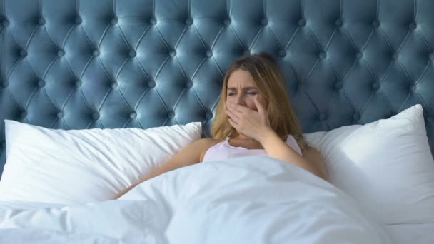 Γυναίκα ξαπλωμένη στο κρεβάτι χασμουριέται, προσπαθεί να χαλαρώσει στο δωμάτιο του ξενοδοχείου, θορυβώδεις γείτονες — Αρχείο Βίντεο