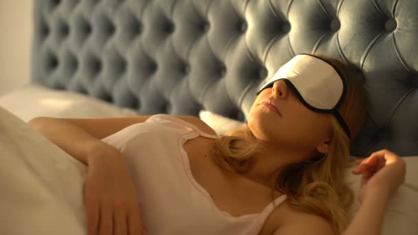 Kobieta zdejmująca opaskę na oczy, rozdrażniona światłem słonecznym wczesnym rankiem, zaburzenia snu — Wideo stockowe
