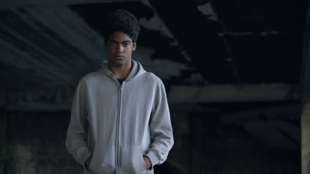 Απελπισμένος έφηβος με κουκούλα που κοιτάζει κάμερα στέκεται εγκαταλελειμμένο κτίριο — Αρχείο Βίντεο