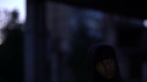 Афро-американський бандит вночі ставить балаклаву на скоєння злочину, грабіжник — стокове відео