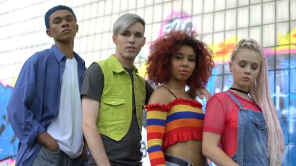 Grupo multirracial de adolescentes mirando la cámara en el fondo de la pared de graffiti, estilo — Vídeos de Stock