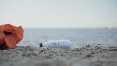 Mesaj Yardım kıyıda duran şişe, kazadan kurtulanları arama konsepti
