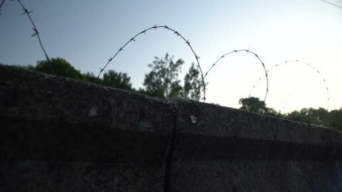 Özgürlük kısıtlamasının sembolü olarak dikenli teller, yasadışı laboratuvarlar, mülteci kampı