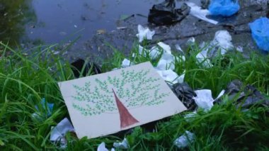 Orman gölü yakınlarındaki çöp sahasına ağaç resmi koyan kişi, doğa kavramını kurtarır.