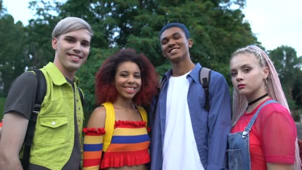 Sonriendo estudiantes universitarios que buscan cámara al aire libre, programa educativo de intercambio — Vídeo de stock