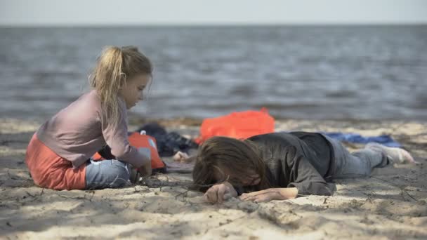 Мать-беженка и ребенок, пережившие кораблекрушение на берегу, незаконное пересечение границы — стоковое видео